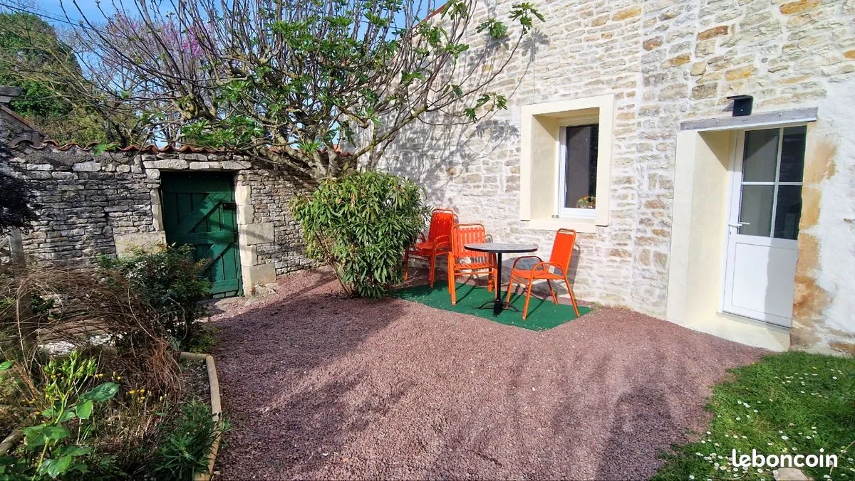 L'extérieur du gîte en pierre, jardin fleuri et terrasse