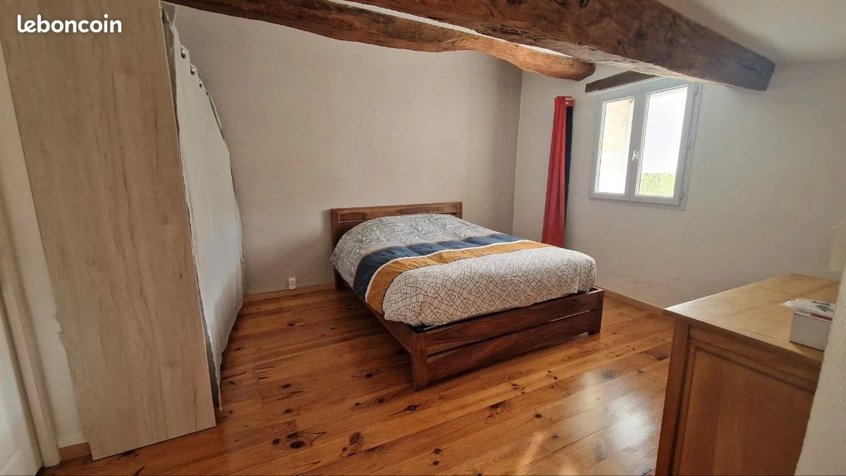 Chambre avec lit double et plancher en bois