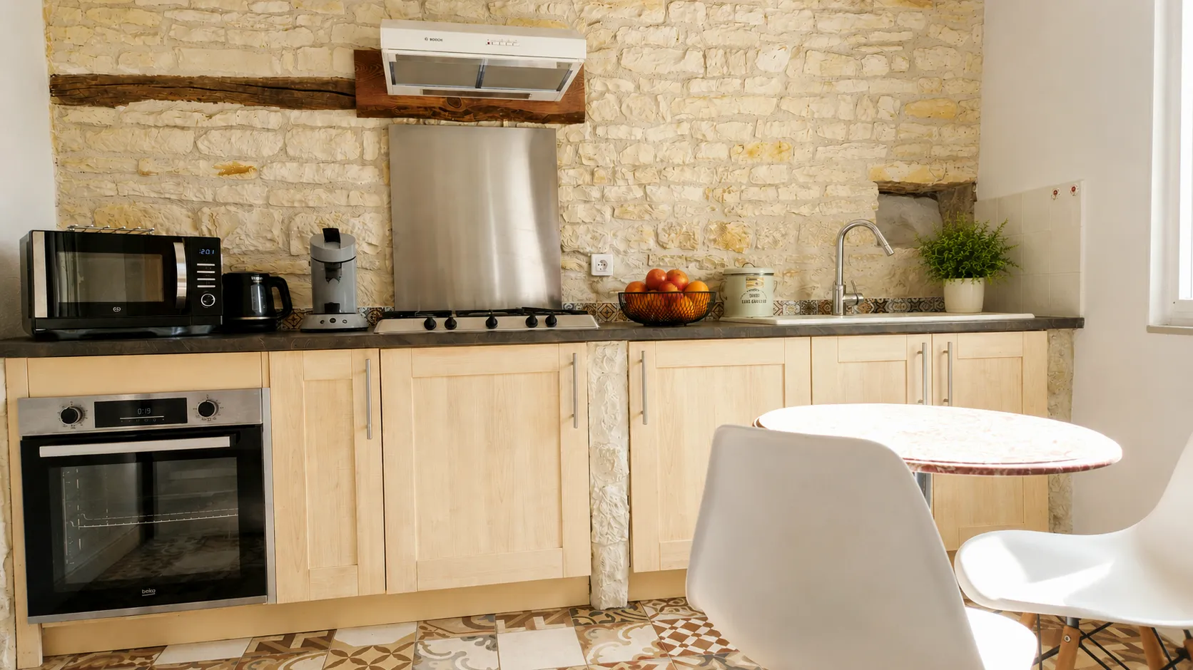 Cuisine équipée sous un mur de pierre apparente